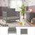 A cozy nursery featuring the Child Craft Atwood 2-Piece Nursery Set with a gray convertible crib and dresser, plus a plush rug, toy train, yellow stuffed duck, tall green plant, purple wainscoting, light wallpaper, and large window with white curtains.