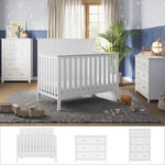A nursery featuring the Child Craft Atwood 3-Piece Nursery Set—white convertible crib, dresser, and chest—rests on a gray rug. Toys, plants, and decor accent blue and gray star-patterned walls, with natural light streaming through a window.