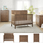 A nursery with the Child Craft Atwood 3-Piece Nursery Set, featuring a crib, dresser, and chest, pairs wooden furniture with light walls, patterned wallpaper, a large window with white curtains, and cozy decorative accents.