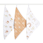 Three hanging aden + anais boutique 100% cotton muslin oversized washcloths: one with small animal illustrations on thicker fabric, another featuring white circular designs on a brown base, and the third displaying abstract shapes in soft colors.