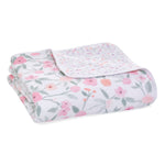 The aden + anais boutique cotton muslin dream blanket features a floral pattern with pink and peach flowers, green leaves on a light background, and a smaller motif on the reverse. Made from 100% cotton muslin, it is breathable and cuddly for ultimate comfort.