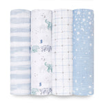 Four aden + anais boutique 100% cotton muslin swaddles are rolled side by side, showcasing patterns like blue stripes, elephants and moons, a starry grid, and a blue sky with celestial designs in calming hues of blue, white, and grey.