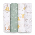 The Disney™ essentials cotton muslin swaddle blanket 4 pack by aden + anais includes four vertically rolled essentials with Winnie the Pooh themes: white with Pooh and forest scenes, green with white outlines, and light brown featuring multiple character patterns.