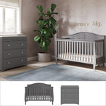 A modern nursery featuring the Child Craft Camden 2-Piece Nursery Set with gray convertible crib and matching dresser, a large potted plant, gray rug, “Dream big.” in gold on a light wall, and a sunlit window.