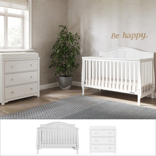 A cozy nursery featuring the Child Craft Camden 2-Piece Nursery Set With Crib and Dresser, plus a potted plant, soft rug on wooden floors, and sunlight from the window. "Be happy." is written above the crib.