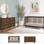 A modern nursery with the Child Craft Cranbrook 2 Piece Nursery Set—convertible crib and 6-drawer dresser in dark wood—plus a round mirror, plush toys, potted plant, light rug, and abstract art. The two Mid Century Modern pieces are shown separately below.