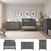 A modern baby’s nursery showcases the Denman 3-Piece Nursery Set with Crib, Dresser, and Chest by Child Craft in a stylish gray finish, all arranged atop a beige rug. Above the crib, three botanical prints add a touch of nature. A plush bunny sits on the floor, surrounded by thoughtfully selected plants and decor accents that enhance the serene atmosphere.