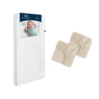 The HALO Breathable Crib Mattress Bundle, featuring a washable white mattress with a baby on the label, is displayed beside two folded beige cotton muslin crib sheets.