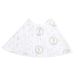 The aden + anais essentials cotton muslin burpy bib is a white triangular bib featuring a bunny inside a floral wreath and scattered floral designs, offering style and practicality with its absorbent fabric.