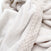 The aden + anais essentials plush blanket features a soft, cream-colored fleece with a textured, woven edge. Its plush fabric appears cozy with gentle folds, suggesting warmth and thickness. Ideal for babies, it promises comfort in any modern setting.