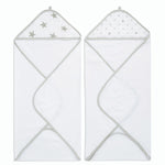 The aden + anais essentials cotton muslin hooded towels 2 pack includes two white plush cotton terry towels with gray edges. The left towels muslin hood has silver stars, and the right one features silver polka dots. Both are unfolded with hoods at the top.