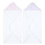 The image shows two aden + anais essentials cotton muslin hooded towels. The left towel features a pink floral hood, and the right one displays a purple leaf design. Both unfolded, these super absorbent towels reveal their full beauty and charm.