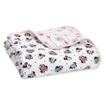 The aden + anais Disney™ essentials cotton muslin dream blanket is a soft, cloud-like folded blanket with colorful cartoon mouse faces. Some wear bows, others don hats, all in cozy cotton muslin with a gentle texture and rounded edges.