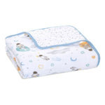 The aden + anais essentials cotton muslin dream blanket is cozy with playful astronaut, planet, and star designs. It features blue edging and a white inner lining with dotted patterns, making it perfect for tummy time.