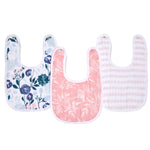 Displayed are aden + anais essentials cotton muslin snap bibs: the left features blue/pink floral patterns, the middle is pink with a white bird and botanical design, and the right has pink/white stripes.