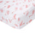 The essentials cotton muslin crib sheet by aden + anais features a playful pattern of stylized pink flamingos in various poses on white fabric, adding a lighthearted touch to the nursery. Made from cotton muslin, the sheet is neatly wrapped and fitted for cribs.