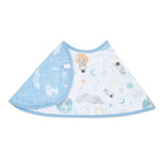 The aden + anais essentials cotton muslin burpy bib features a circular design with a blue edge and space-themed pattern, including astronauts and planets, on absorbent muslin. This full-coverage bib offers style and practicality for your little explorer.