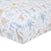 The aden + anais essentials cotton muslin crib sheet features hand-drawn animals like giraffes, elephants, and alligators in pastel colors—blue, green, and beige—on cozy white cotton muslin. These whimsical nursery prints are scattered across the fabric.