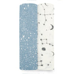 The aden + anais essentials silky soft swaddle blanket 2 pack features two rolls: one bamboo-infused blue with white speckles, and the other white with black moon, star, and constellation patterns. Perfect for a babys sensitive skin, they are displayed side by side on a white background.