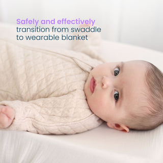 A baby lies on their back wearing a HALO Easy Transition SleepSack TOG 1.5, a quilted long-sleeved wearable blanket designed to help with the swaddle transition and better sleep.