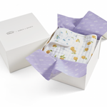 A white Gift Box by HALO, partially open with purple tissue paper, reveals a folded white baby blanket featuring blue trim and a lemon print.