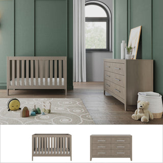 A modern nursery with green walls features the Child Craft Kieran Euro 2-Piece Nursery Set—convertible crib and dresser—plus framed art, toys, a rug on wood floors, and a large window with white curtains letting in natural light.