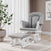 A Child Craft Scout 4 Piece Nursery Set, featuring a gray upholstered glider chair with matching ottoman, rests on a round patterned rug beside a large potted plant and sheer white curtains in a softly lit, modern room—perfectly complementing the elegant nursery furniture.