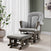 A cozy nursery featuring the Child Craft Hampton Arch Top 3 Piece Nursery Set—including a stylish gray upholstered glider chair with matching ottoman—sits on a light wood floor beside a potted plant and a window adorned with sheer white curtains. Abstract art accents the pale green wall, completing the serene space.