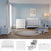 A light blue nursery is furnished with the Child Craft Scout 4 Piece Nursery Set, which includes a white 4-in-1 Convertible Crib, dresser, and toy box. Nearby, a gray glider chair with ottoman provides a cozy seating area, while a round beige rug softens the wooden floor and framed artwork hangs above the crib.