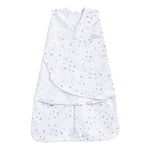 The HALO Swaddle 100% Cotton TOG 1.5 is a white swaddle featuring blue star and moon patterns. It includes adjustable Velcro wings and a front zipper for easy access. Made from soft, breathable fabric, it supports healthy hip development for safe and comfortable sleep.