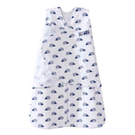 A white HALO Swaddle 100% Cotton TOG 1.5 with small blue turtle patterns, a double zipper, and BACK IS BEST printed on it. It features a sleeveless design and adjustable wings to keep your baby snug and secure.