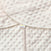 A close-up of the textured, cream Swaddle Plushy Dot Velboa TOG 3.0 fabric by HALO reveals raised dots and a small HALO tag at the overlapping seam with adjustable wings for healthy hip development.
