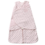 The HALO Swaddle Plushy Dot Velboa TOG 3.0 in light pink has a textured polka dot pattern, front zipper, adjustable wings for secure swaddling with Velcro closure, and an embossed logo on the upper front to promote healthy hip development for your infant.