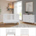 A contemporary nursery showcases the Child Craft Soho 2-Piece Nursery Set with Crib and Dresser, both in white with wooden legs, complemented by neutral walls, stylish shelving, greenery, framed artwork, and a large window that fills the space with natural light.