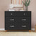 A sleek black dresser with four drawers, silver handles, and wooden legs stands against a pink wall, capturing the clean lines of mid-century modern design. Carefully arranged atop are decorative accents—a white coral sculpture, a vibrant plant, and framed artwork—offering the perfect finishing touches for your contemporary nursery. Pair this look seamlessly with the Child Craft Soho 3-Piece Nursery Set with Crib, Dresser and Chest to elevate your space or complement other pieces from the collection.