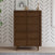 A stylish and functional dresser from the Child Craft Surrey Hill 3-Piece Nursery Set with Crib, Dresser, and Chest stands against a white wall adorned with black chevron patterns. Featuring six drawers, this mid-century modern wooden piece is topped with décor items like a giraffe figurine and framed art—making it an elegant addition to any nursery.