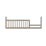 The Child Craft F09503 Toddler Guard Rail in Crescent Grey features vertical slats and mounting brackets, designed for secure attachment to a Child Craft crib as a toddler guard rail for added safety.