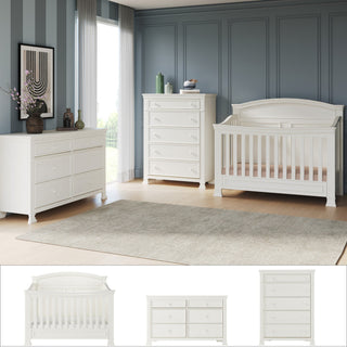 A modern nursery featuring the Child Craft Westgate 3-Piece Nursery Set with Crib, Dresser, and Chest arranged on a beige rug, set against blue paneled walls with large windows and contemporary art.