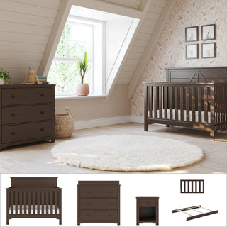 A cozy nursery with a sloped ceiling, large window, light walls, leafy wallpaper, a round white rug, and the Child Craft Woodland 5-Piece Nursery Set featuring a dark wood 4-in-1 convertible crib, dresser with changing tray, and matching nightstand.