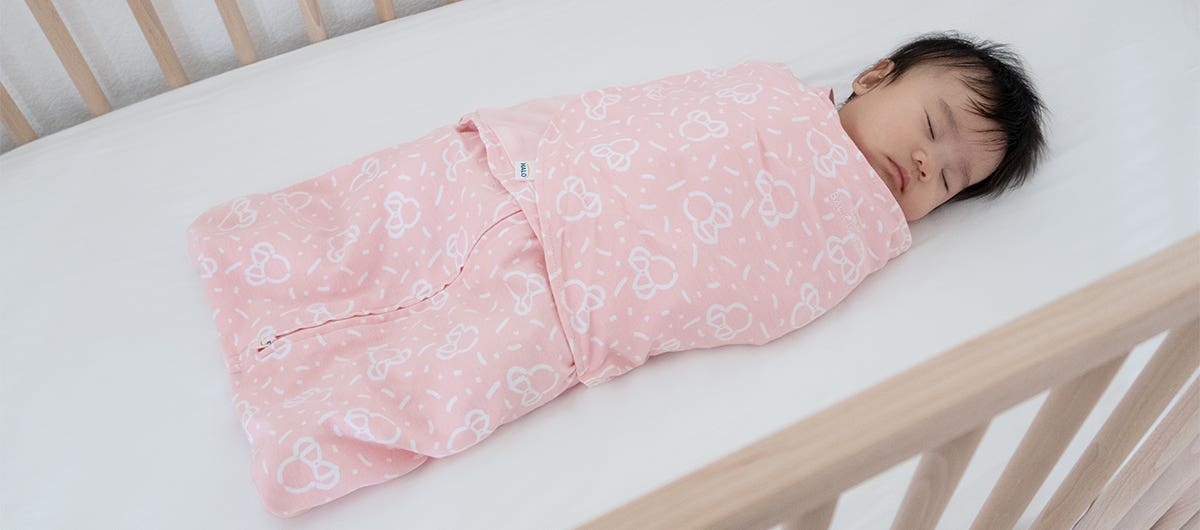 baby sleeping in halo disney sleepsack swaddle in minnie mouse pink print